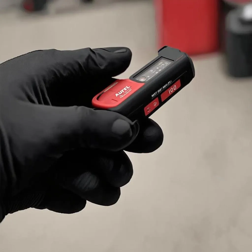 Autel MV101 Digital Inspection Camera held by a hand wearing a mechanic glove.