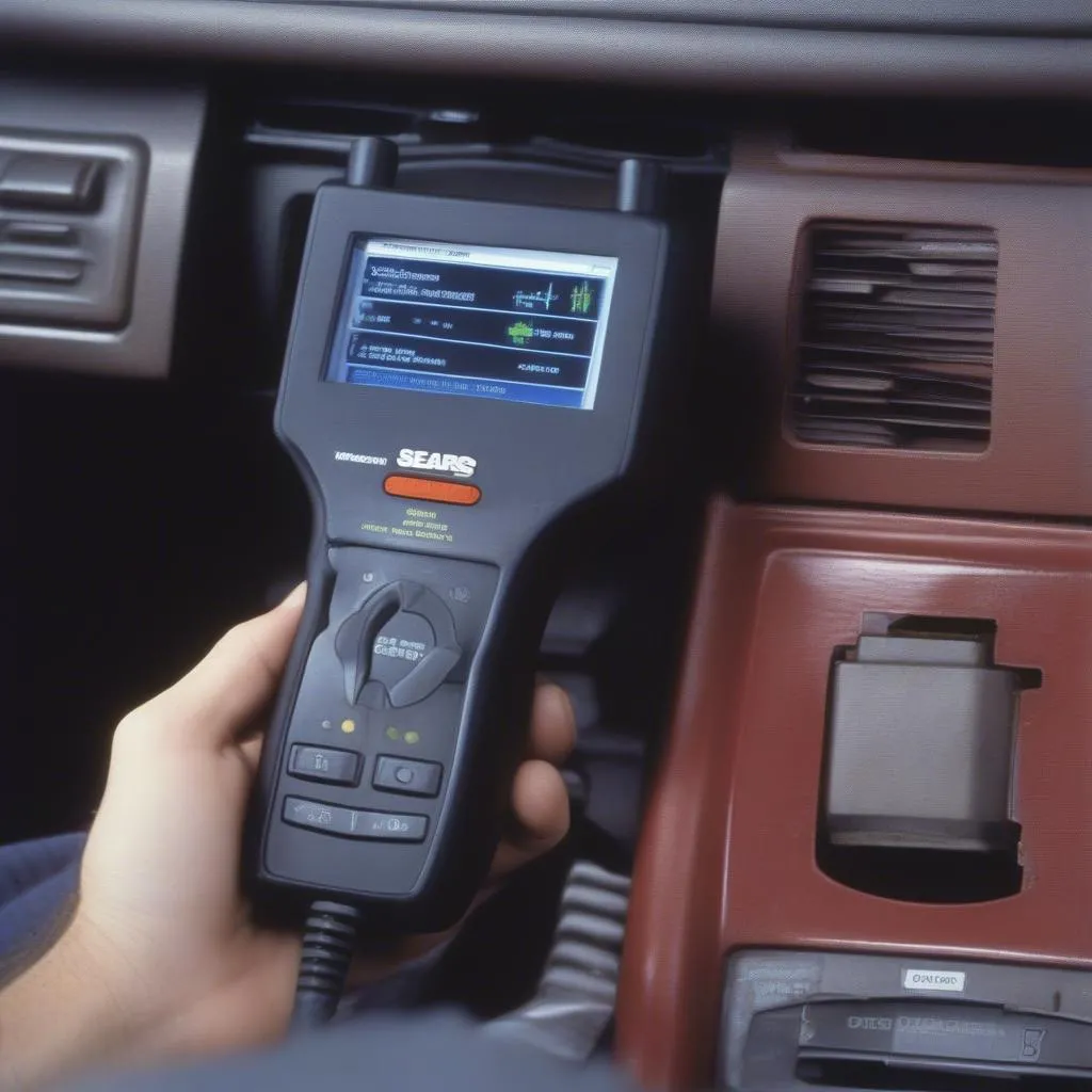 A Sears Diagnostic Scan Tool connected to a car's OBD-II port